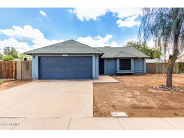 Front exterior with a gray door, gravel lawn, and concrete driveway at 161 S Maple St, Chandler, AZ 85226