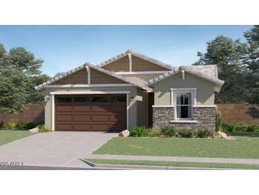 Charming single-story home featuring a stone facade accent, a two-car garage, and manicured landscaping at 17349 W Smoketree Dr, Surprise, AZ 85387