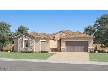 Charming single-story home with stone accents, a two-car garage, and a well-manicured lawn at 17411 W Swayback Pass, Surprise, AZ 85387