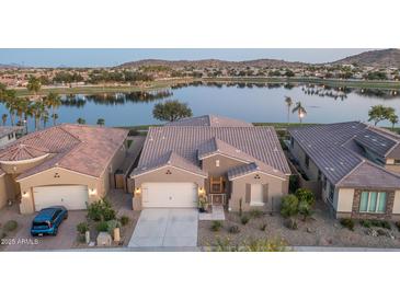 Stunning waterfront home featuring desert landscaping, tile roof, and attached two-car garage at 18135 W Hope Dr, Goodyear, AZ 85338