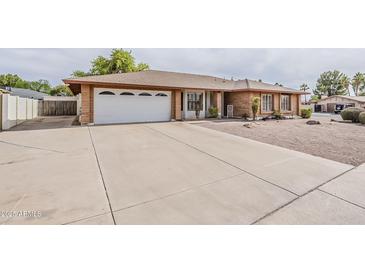 Charming single-story brick home with a spacious driveway and two-car garage at 2605 E Fountain St, Mesa, AZ 85213