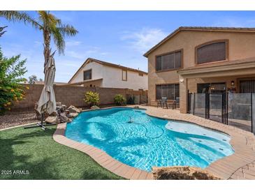 Beautiful backyard pool with rock waterfall feature and well maintained turf and landscaping at 4323 E Dublin St, Gilbert, AZ 85295