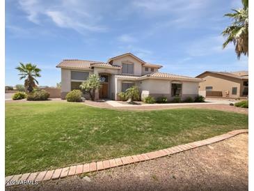 Two-story home boasts lush green lawn, mature trees, and well-maintained landscaping at 5501 W Whispering Wind Dr, Glendale, AZ 85310