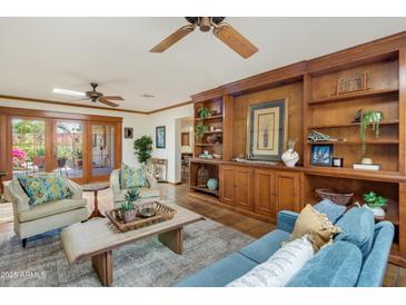 Inviting living room features a custom built-in, Saltillo tile floors, and neutral furnishings at 7526 E Edgemont Ave, Scottsdale, AZ 85251