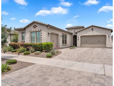 Charming single-story home featuring a brick driveway, manicured landscaping, and a two-car garage at 10006 E Rotation Dr, Mesa, AZ 85212