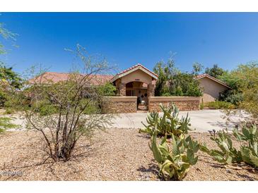 Charming single-story home with desert landscaping, a cozy courtyard, and a warm, inviting exterior at 12837 N 68Th St, Scottsdale, AZ 85254
