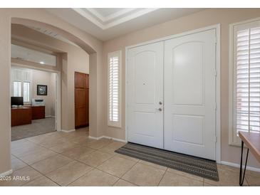 Welcoming foyer with tiled floor, arched entryway, and double front doors with window shutters for added privacy at 18226 W Stinson Dr, Surprise, AZ 85374
