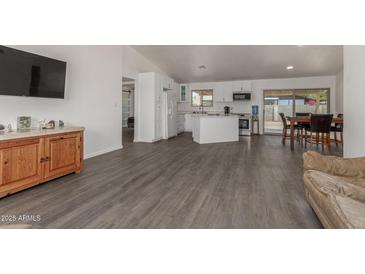 Open-concept living room featuring modern gray flooring and flowing access to the kitchen and dining area at 2826 E Cactus Rd, Phoenix, AZ 85032