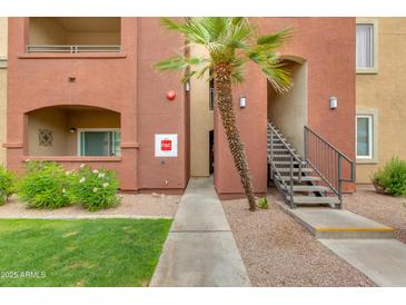Apartment exterior with well-kept landscaping, stairs to upper units and a palm tree at 5401 E Van Buren St # 1004, Phoenix, AZ 85008