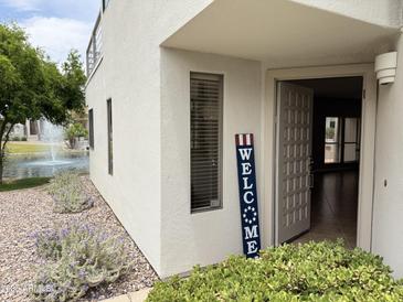 Inviting home exterior with a charming welcome sign near the front door and views of the water fountain at 7272 E Gainey Ranch Rd # 122, Scottsdale, AZ 85258