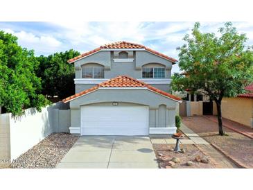Charming two-story home featuring a white garage door, desert landscaping, and a classic red-tiled roof at 909 W San Mateo Ct, Gilbert, AZ 85233