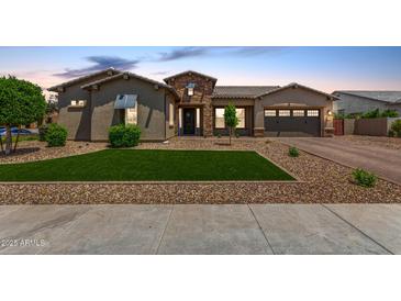 Beautiful single-Gathering home with a well-manicured lawn, desert landscaping, and a charming stone-accented entrance at 9448 W Villa Hermosa --, Peoria, AZ 85383