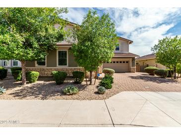 Charming home featuring a well-maintained yard with stone accents and a brick driveway at 14727 W Pasadena Ave, Litchfield Park, AZ 85340