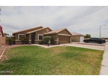 Charming single-story home featuring a well-manicured lawn and desert landscaping at 16036 W Desert Bloom St, Goodyear, AZ 85338
