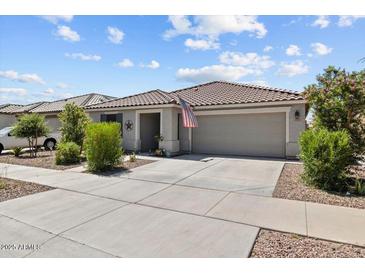 Charming single-story home with a two-car garage, covered porch, and desert landscaping at 17461 W Molly Ln, Surprise, AZ 85387