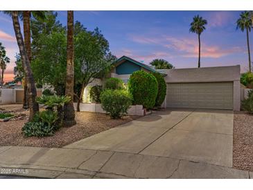 Charming home exterior with a well-maintained lawn, mature trees, and attached two-car garage at 2916 S Revere Cir, Mesa, AZ 85210