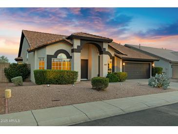Charming single-story home featuring desert landscaping, a two-car garage, and a welcoming front porch at 4329 W Electra Ln, Glendale, AZ 85310