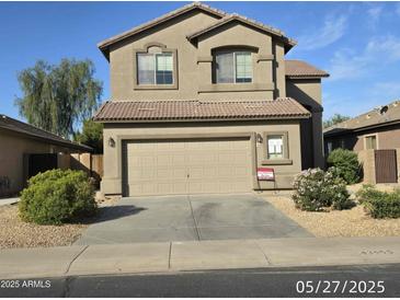 Two story home showcasing desert landscaping, attached two car garage and tile roof at 43455 W Chisholm Dr, Maricopa, AZ 85138