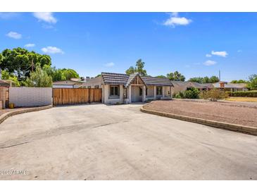 Charming single-story home featuring an expansive driveway and distinctive architectural details at 439 N Cherry --, Mesa, AZ 85201