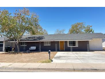 Charming single-story home with a welcoming yellow front door and swing on the front porch at 512 N Ironwood --, Mesa, AZ 85201