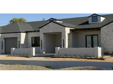 Beautiful single-Gathering home with a stone and stucco exterior, black trim, and a well-manicured front yard at 8521 E Desert Cove Ave, Scottsdale, AZ 85260