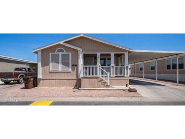 Tan home with a covered porch and carport provides covered parking at 9431 E Coralbell Ave # 6, Mesa, AZ 85208