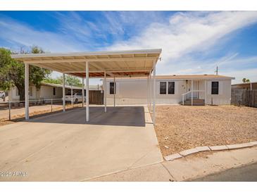 Charming single-story home featuring a covered carport and a low-maintenance desert landscape at 231 N 88Th Way, Mesa, AZ 85207
