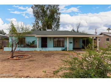 Quaint single-story home with a light blue exterior and covered entrance nestled on a lot with mature trees at 2944 W Northern Ave, Phoenix, AZ 85051