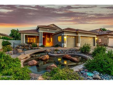 Stunning home featuring a decorative pond, three-car garage, and manicured desert landscaping at 321 W Brooks St, Gilbert, AZ 85233