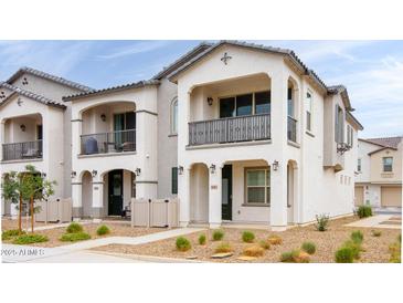 Charming two-story townhome featuring a private balcony, neutral stucco, and well-maintained landscaping at 4063 E Amoroso Dr, Gilbert, AZ 85296