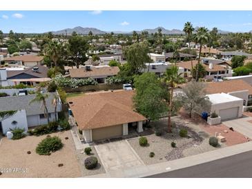 A sunny aerial view of a single story home with desert landscaping and a two car garage in a well-kept community at 6725 E Kings Ave, Scottsdale, AZ 85254
