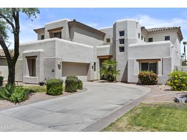 Stunning two-story home with a circular driveway, desert landscaping, and a three-car garage at 7262 E Lupine Ave, Scottsdale, AZ 85260