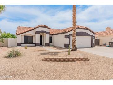 Charming single-story home with a well-maintained yard and a two car garage at 9231 W Grovers Ave, Peoria, AZ 85382