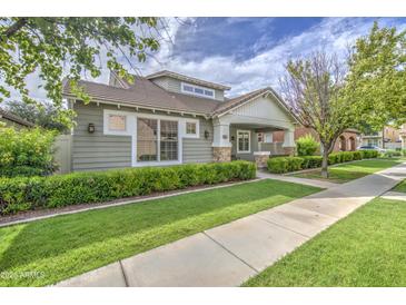 Well-maintained home features manicured landscaping, charming stone accents, and a covered porch at 1143 S Annie Ln, Gilbert, AZ 85296