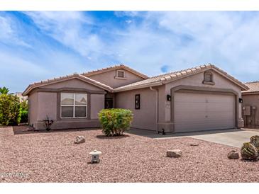 Single story home with a neutral color, low maintenance desert landscaping, and a two car garage at 1395 E Runaway Bay Dr, Chandler, AZ 85249