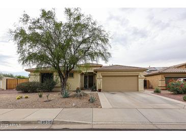 Inviting single-story home featuring a low-maintenance desert landscape and a two-car garage at 18550 W Mcneil St, Goodyear, AZ 85338