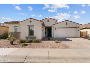 Charming single-story home featuring a well-manicured front yard, paver driveway, and a two-car garage at 21132 W Windsor Ave, Buckeye, AZ 85396