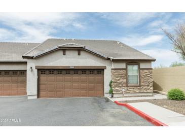 Attached garage doors, stone accents, and well-maintained landscaping enhance this beautiful home at 2725 E Mine Creek Rd # 1208, Phoenix, AZ 85024