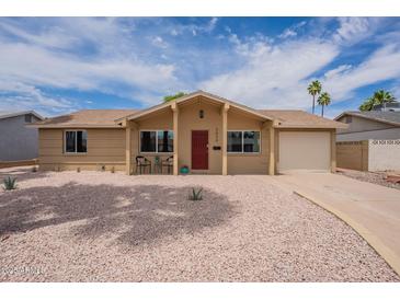 Charming single-story home with desert landscaping, attached garage, and red front door at 3620 E Ludlow Dr, Phoenix, AZ 85032
