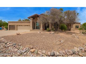 Beautiful desert home with drought-resistant landscaping and a three-car garage at 4922 W Fallen Leaf Ln, Glendale, AZ 85310