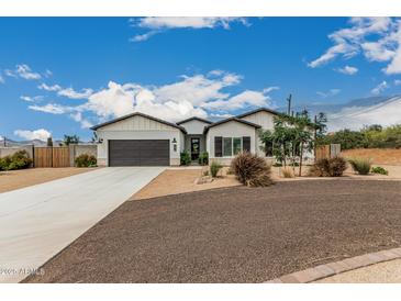 Charming single-story home featuring desert landscaping, gray stucco, and a spacious driveway at 5670 E Singletree St, Apache Junction, AZ 85119
