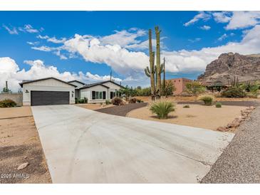 Charming single-story home with a two-car garage and a well-manicured desert landscape at 5670 E Singletree St, Apache Junction, AZ 85119