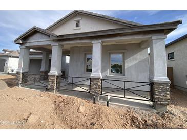 New construction home showing inviting covered front porch with stone column accents and metal railing at 1171 E Peach Tree Dr, Chandler, AZ 85249