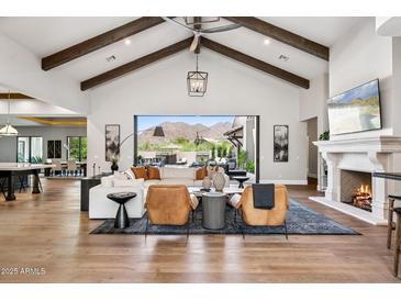 Bright living room with high ceilings, exposed beams, fireplace, and sliding glass doors to the backyard at 13750 E Yucca St, Scottsdale, AZ 85259