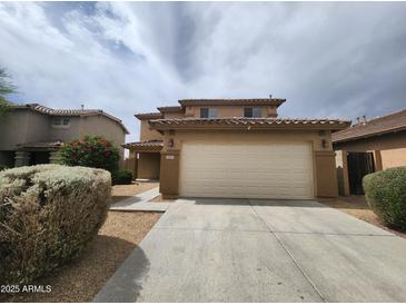 Charming two-story home featuring a two-car garage, desert landscaping, and a tile roof at 13921 W Port Royale Ln, Surprise, AZ 85379