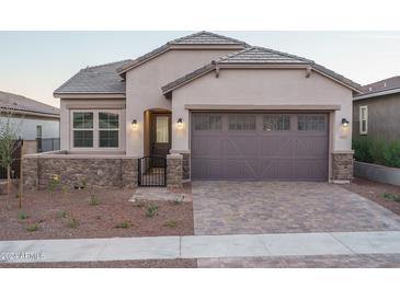 Charming single-Gathering home featuring a gray garage door and brick-paved driveway at 20961 W Pasadena Ave, Buckeye, AZ 85396