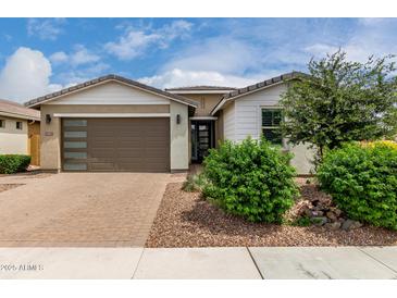 Charming single-story home with a brick driveway, lush landscaping and a two-car garage at 22568 E Rosa Rd, Queen Creek, AZ 85142