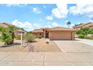 Charming single-story home with a well-maintained yard and a two-car garage at 7214 W Crest Ln, Glendale, AZ 85310