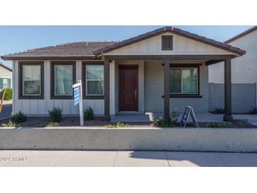 Charming single-story home with a well-manicured front yard and covered porch, creating inviting curb appeal at 1057 S 151St Ln, Goodyear, AZ 85338