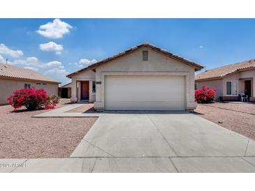 Home with a driveway and two-car garage complemented by lovely desert landscaping and an inviting entrance at 12233 W Aster Dr, El Mirage, AZ 85335